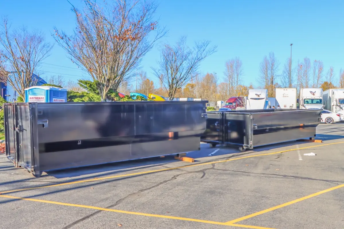 Professional dumpster rental service with roll-off container on residential driveway in Ludlow